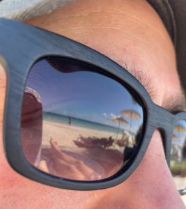 Dan's sunglasses reflect the beach