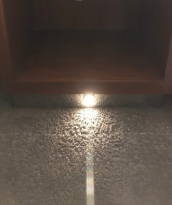 A light shines at the bottom of a nightstand