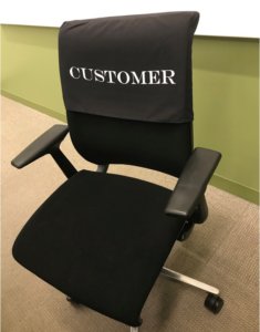 A chair at Comcast headquarters has the word "customer" on it.