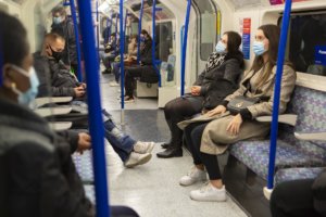 passengers on a train wearing masks
