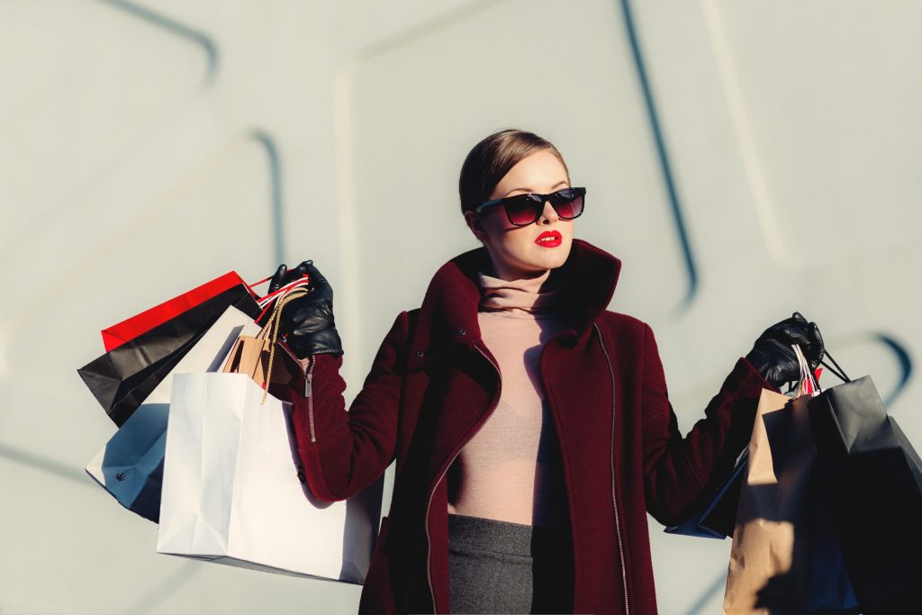 Woman carrying multiple shopping bags. Customers are switching brands more often than ever before.