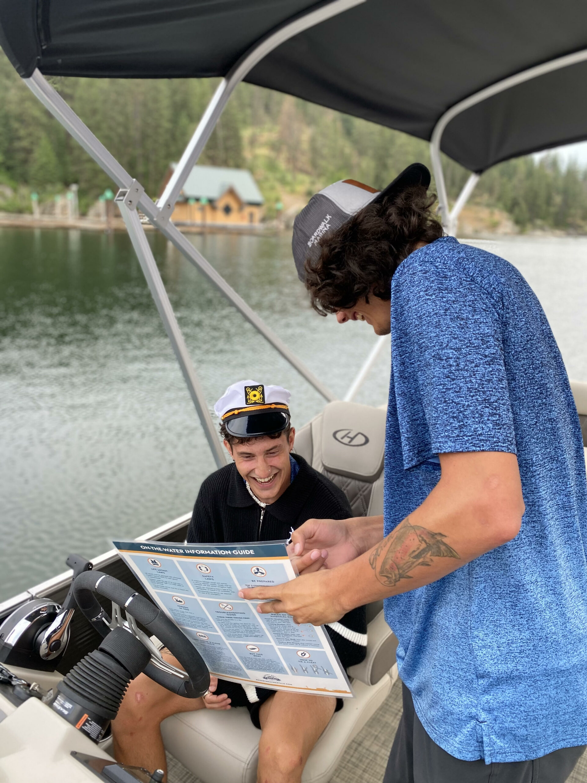 A boat renter in a captain's hat receives instructions from an expert.