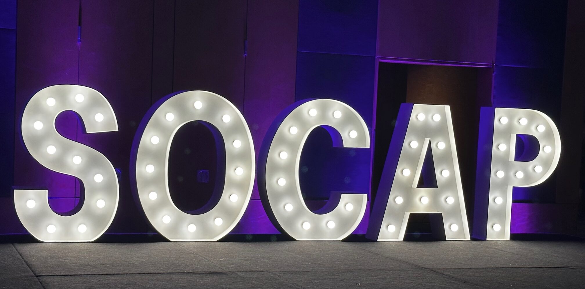 A lighted sign of 5 big letters spelling "SOCAP" - the association dedicated to helping professionals in charge of resolving customer disputes.