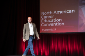 Keynote Speaker Dan Gingiss walks onto the stage at the North American Career Education Convention. He spoke about elevating the customer experience.