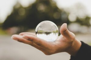 A hand holding a crystal ball to symbolize the CX predictions for 2024 that our experts shared. 
