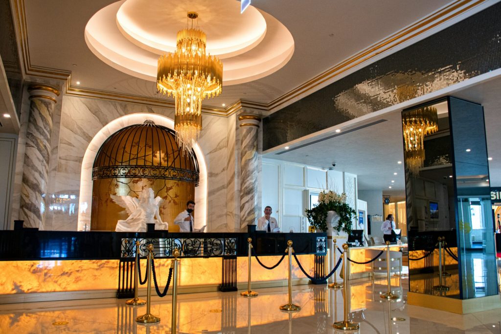 A large chandelier hangs over a hotel check-in, and example of a luxury customer experience.